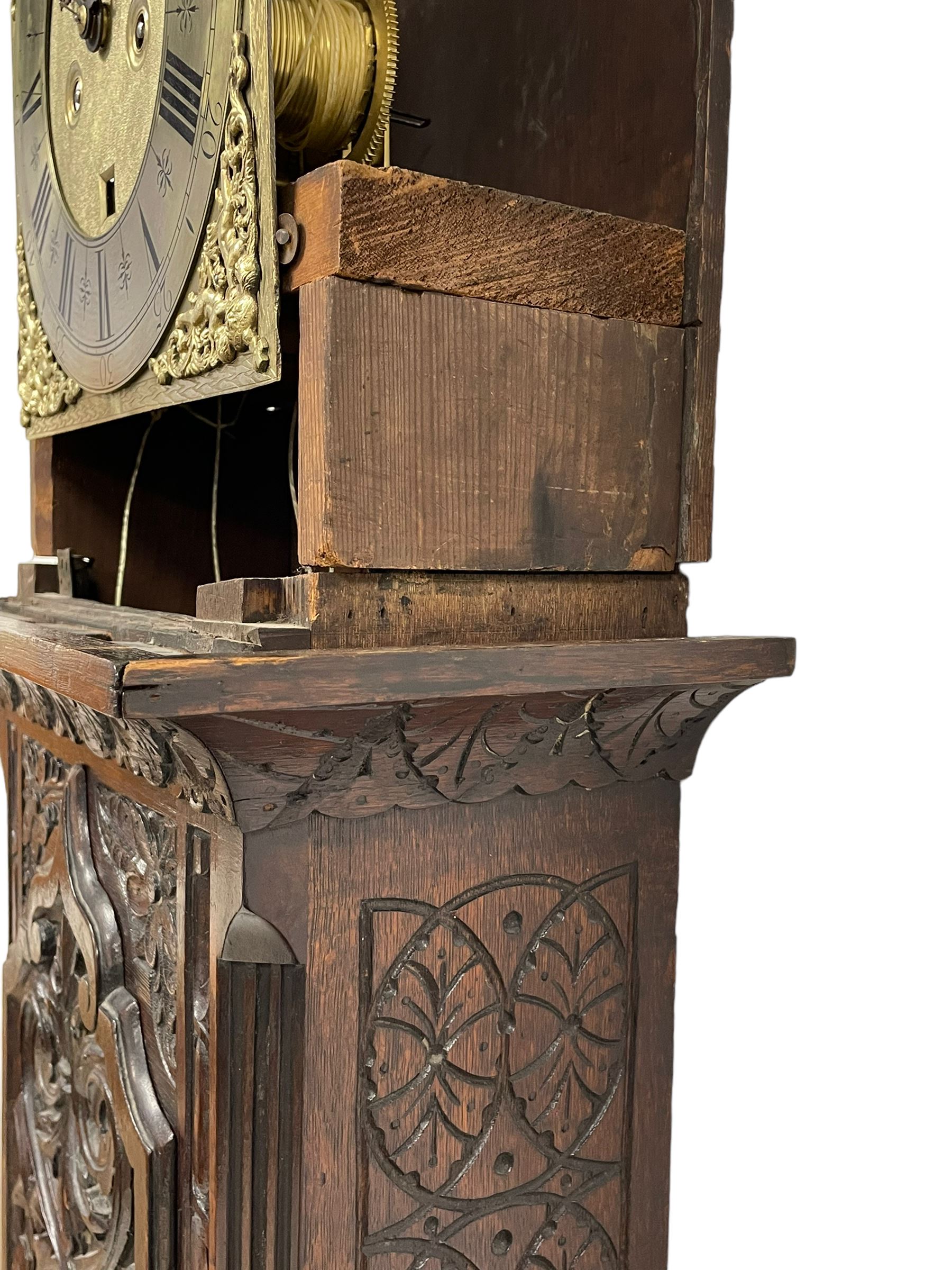 18th-century profusely carved oak longcase clock - with a pagoda pediment, upstands and carving, 
 break arch hood door flanked by reeded pilasters with brass capitals, trunk with canted corners and a spire topped door, square plinth with applied skirting, break arch brass dial with wheatsheaf engraving and cast cherub and crown spandrels, engraved break arch with the London clockmakers name John Gordin, silvered chapter ring with Roman numerals, five minute Arabic's, minute and quarter hour tracks, matted dial centre with ringed winding holes, square date aperture and seconds ring, dial pinned to a five pillar movement with inside countwheel striking, striking the hours on a cast bell. With weights and pendulum. John Gordin, is possibly a mis-spelling or phonetic spelling of John Gordon, of London, who worked from Ludgate Street in the parish of St. Gregory by St. Pauls. Apprenticed in 1689 and died in 1732 when his will was proven.
