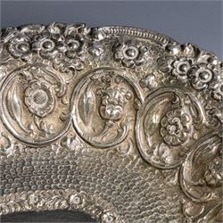 Late 19th/early 20th century continental silver serving bowl, of oval form, profusely embossed with scrolling floral and foliate decoration, with hammered finish to interior
