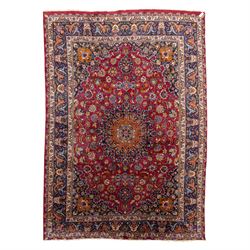 Persian Kashan wool carpet, red field centred with large floral medallion and conforming p...