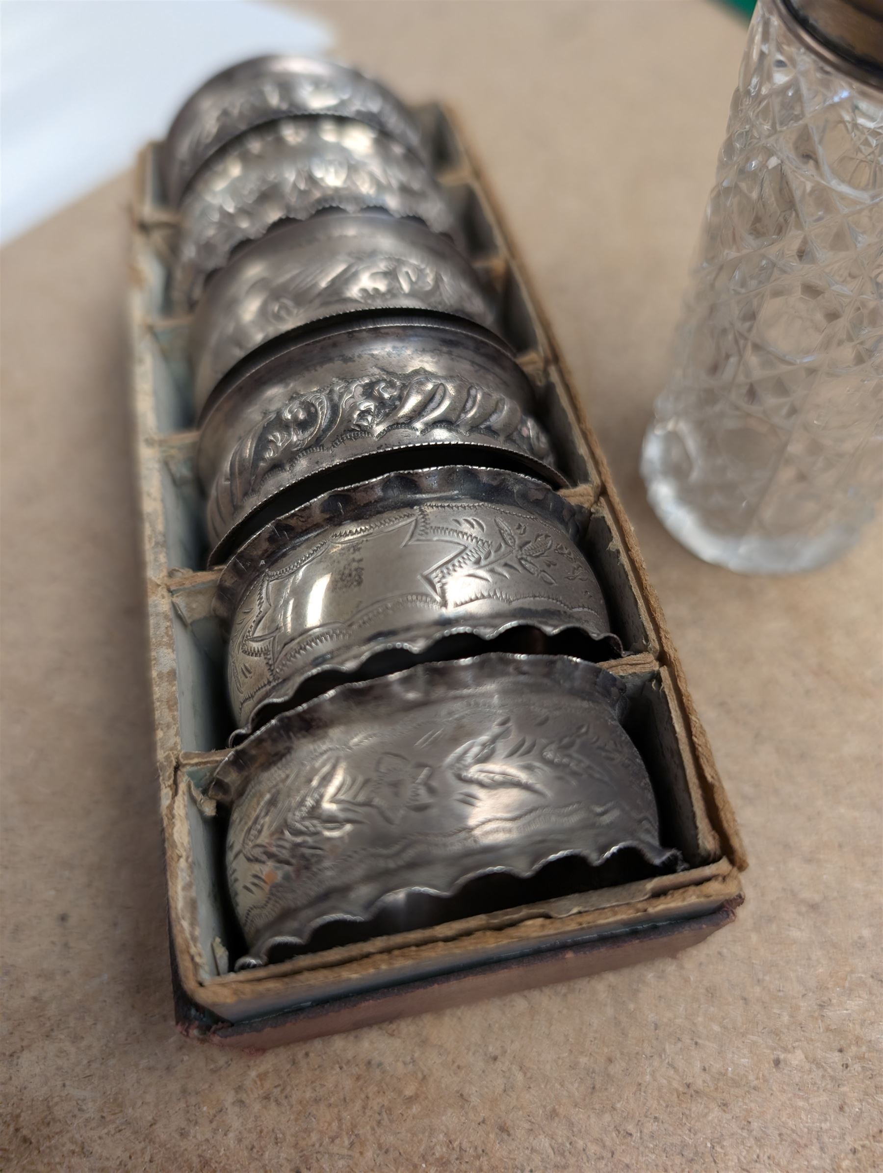 Six silver napkin rings, together with a silver topped cut glass jar, all hallmarked