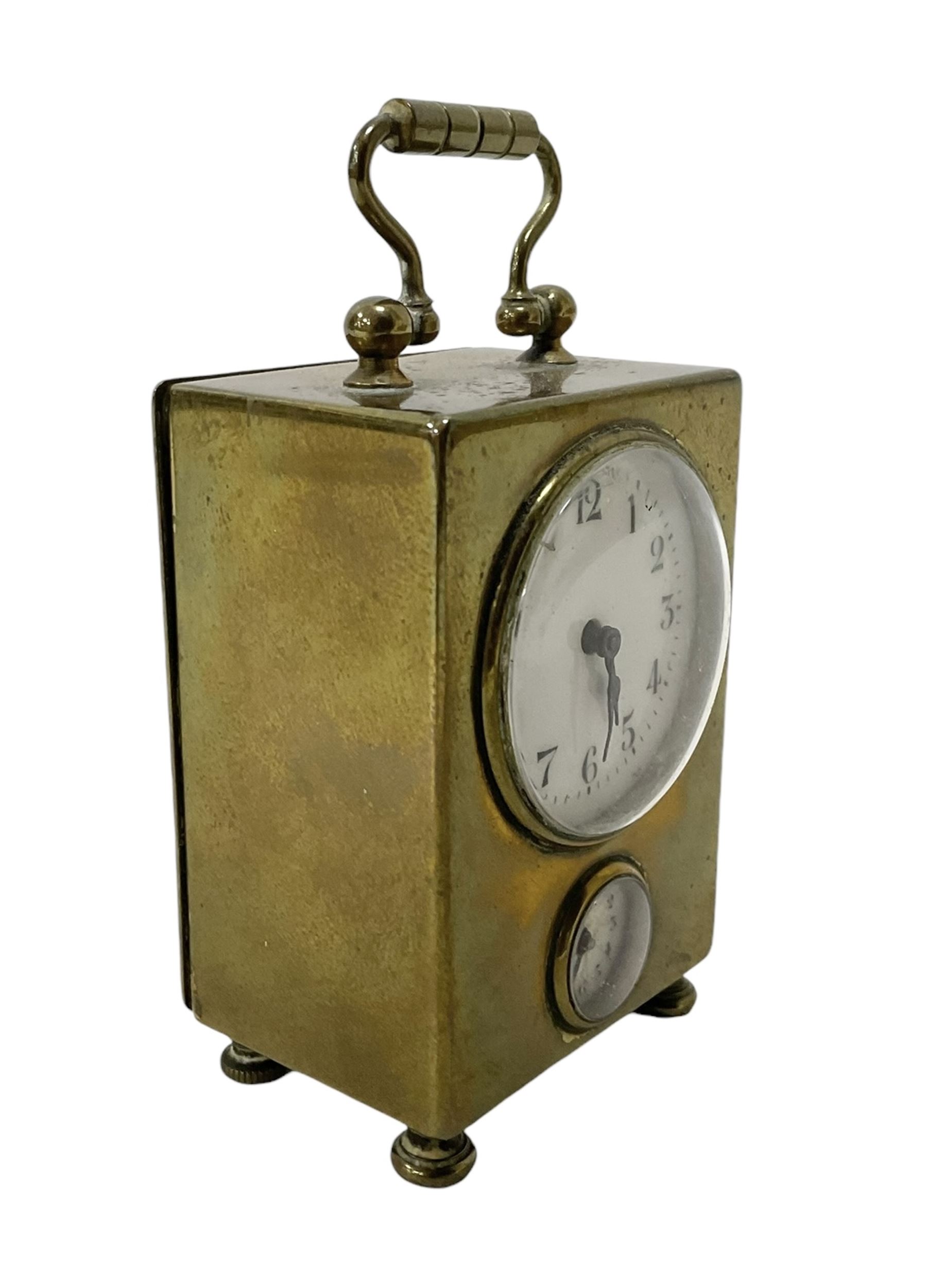 French - petite early 20th century French brass cased travelling alarm clock, with bun feet and carrying handle, circular enamel dial with Arabic numerals and spade hands, conforming alarm setting dial beneath, with a platform escapement, wound and set from the rear.