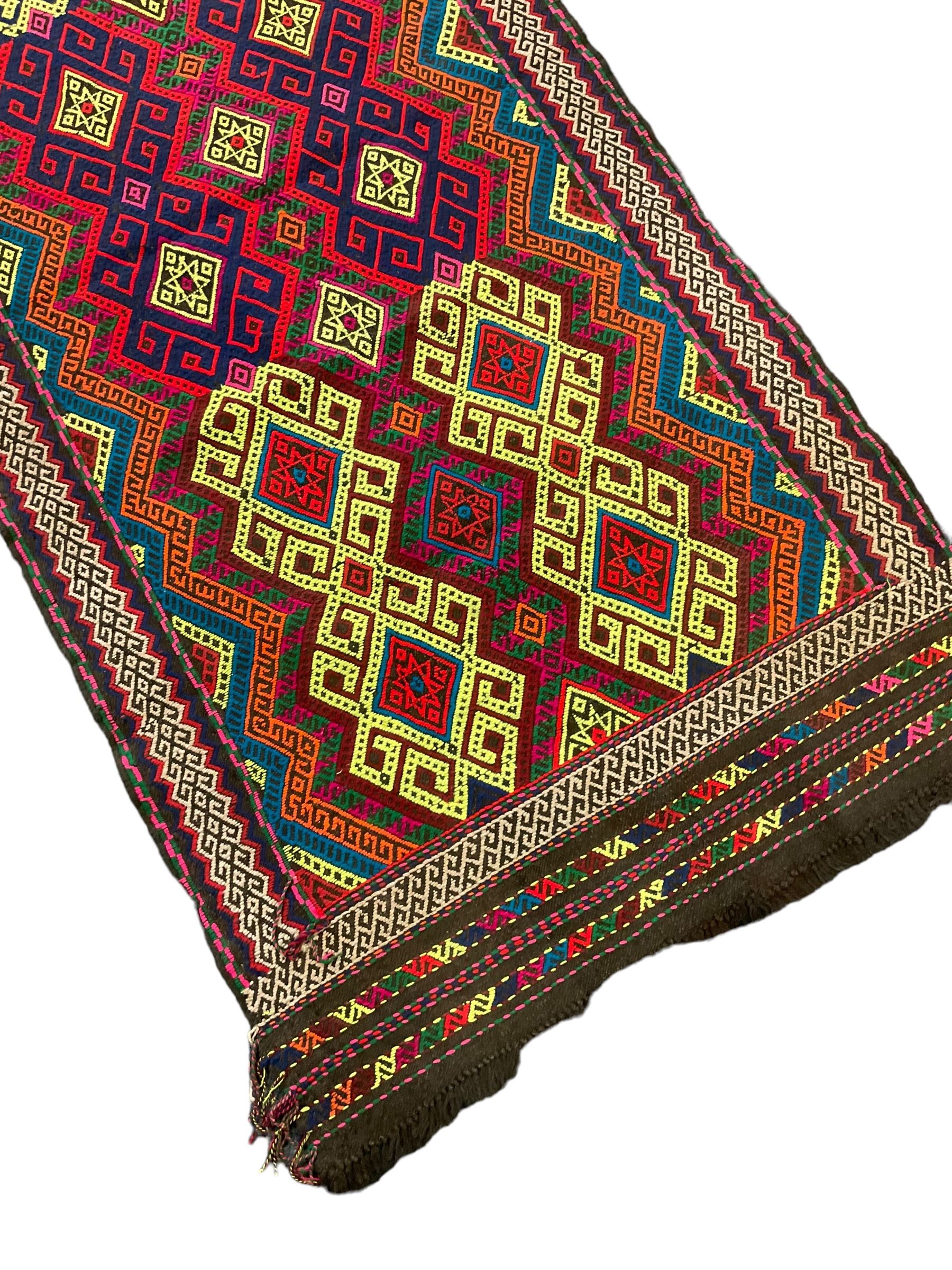 Flatweave geometric design rug, decorated with trailing hooked medallions within zig-zag bands, bright multi-coloured ground 