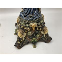 Composite table lamp modelled as a Roman Emperor donning blue robes, upon quatrefoil base modelled with rams heads and winged cherubs, H56cm excl fitting