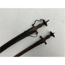 Late 19th/early 20th century Indian Tulwar sword with 81cm plain curving steel blade and iron hilt with extended langets, knucklebow and spiked pommel; in leather covered scabbard L100cm overall; and another Tulwar lacking scabbard in almost relic condition (2)