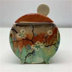 Clarice Cliff Bizarre for Wilkinson Pottery, Bon Jour shape preserve pot decorated in the May Blossom pattern, hand painted with stylised blossom upon a streaked merging green and orange ground, with conforming lift off lid, with black printed mark beneath, H10cm