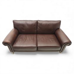 Laura Ashley - brown leather two seater sofa, loose cushion back and seat, flanked by scrolled arms upon light stained wood supports on castors