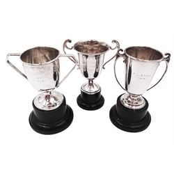 Three small silver twin handled trophy cups, all with personal engraving to body and upon ebonised bases, all hallmarked, tallest H12cm