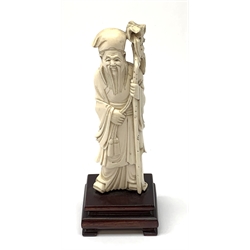 A Chinese carved ivory okimono, modelled as a sage holding a staff, raised upon a wooden base, overall H15.5cm. 