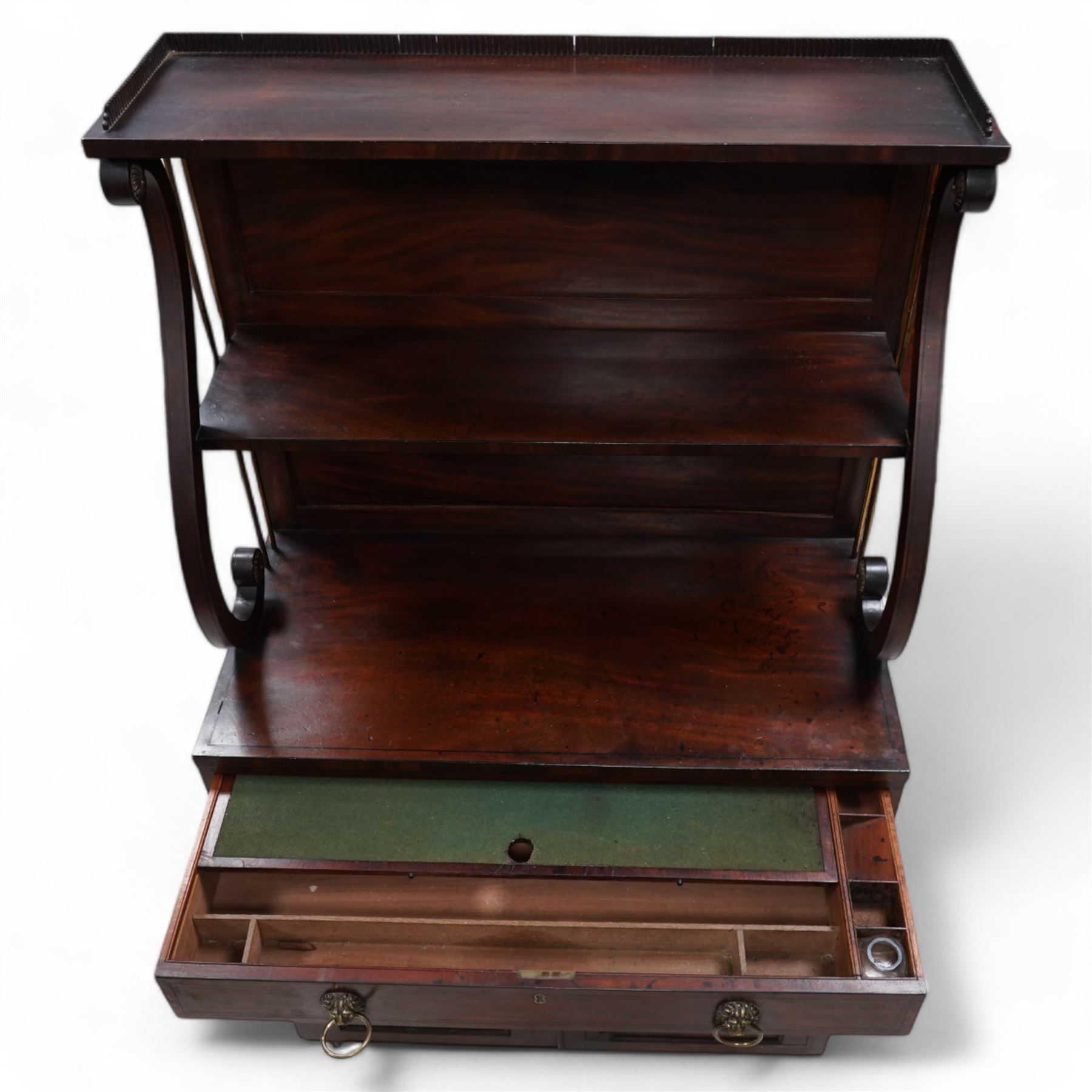 Regency mahogany lyre chiffonier, tall two-tier raised back with serpentine supports and brass pillars, the drawer fitted with sliding writing surface with divisions and pen and ink stands, seven internal drawers with lion mask handles enclosed by panelled doors, inlaid with ebony stringing
