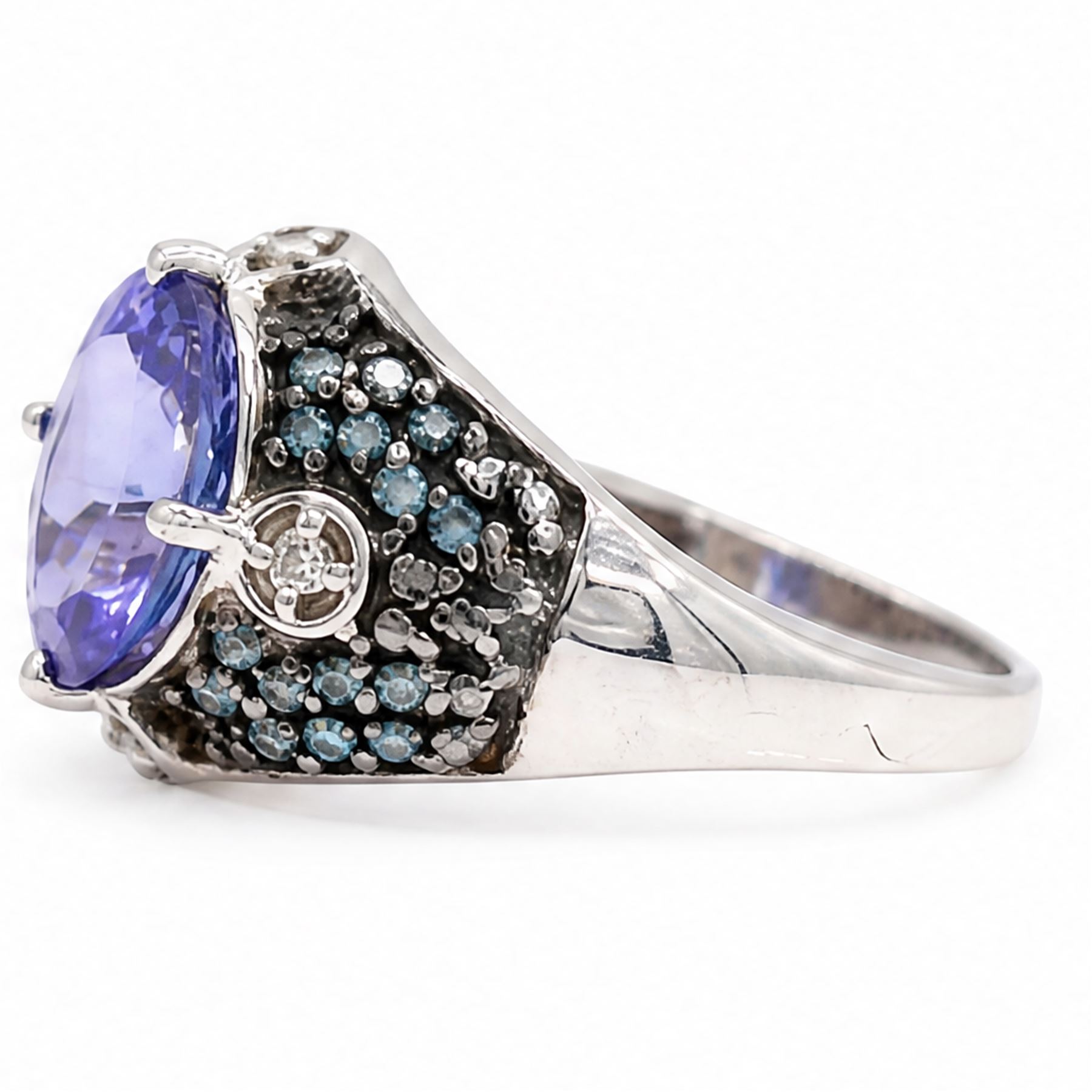 9ct white gold tanzanite and diamond ring, single oval cut tanzanite of approx 1.70 carat, surrounded by four single cut white diamonds and pave set blue diamonds, hallmarked