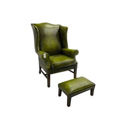George III design wingback armchair, upholstered in buttoned green leatherette with studwork, raised on square tapering supports, and matching footstool