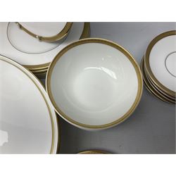 Royal Doulton Royal Gold pattern tea and dinner service for eight, comprising dinner plates, side plates, tea plates, soup bowls, sauce boat and saucer, dessert bowls, coffee cans and saucers, teacups and saucers and two lidded tureens