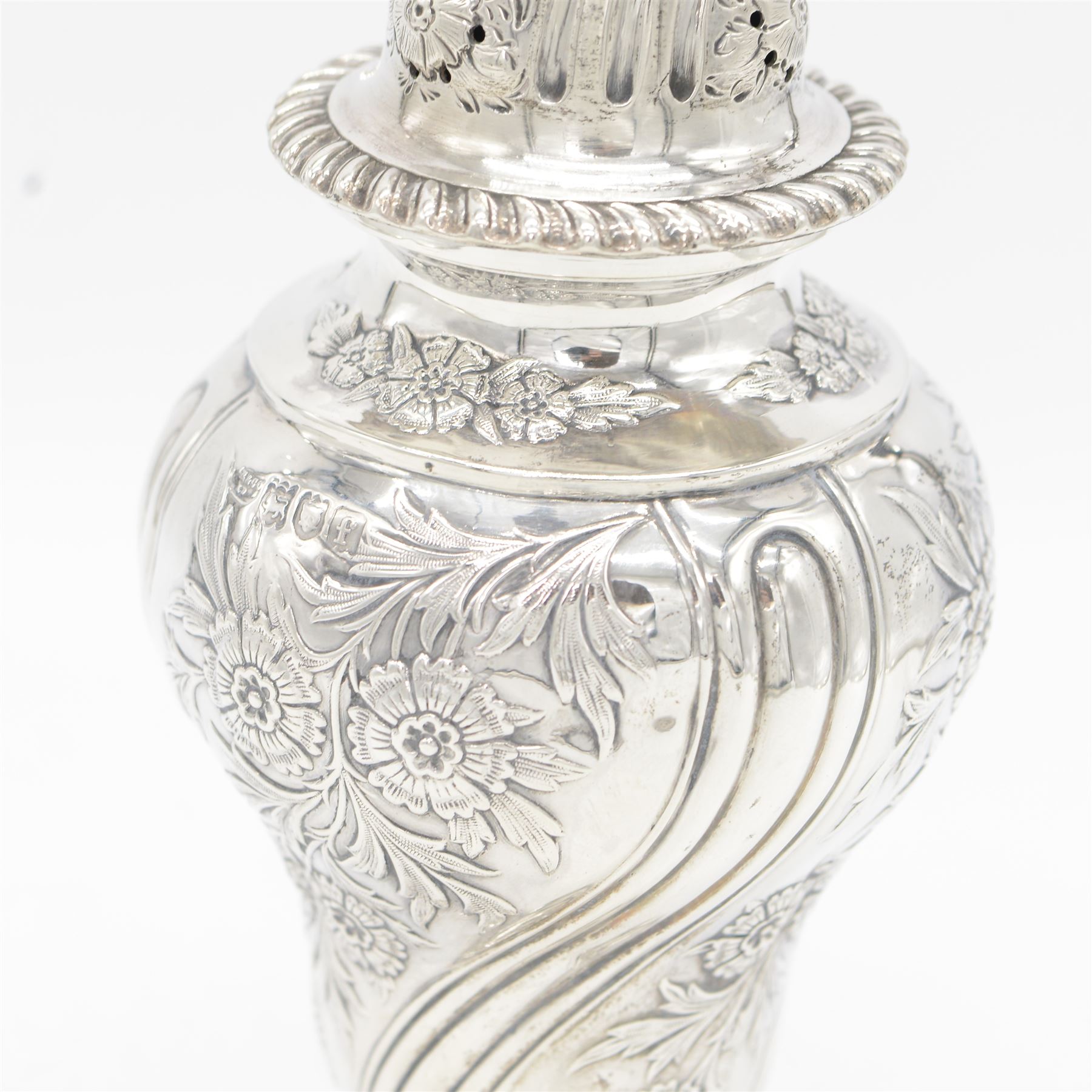 Edwardian silver sugar caster, of typical form embossed with floral decoration, the removable pierced cover with oblique gadrooned rim and bud finial, upon a circular stepped foot, hallmarked Hawksworth, Eyre & Co Ltd, London 1901, H20cm