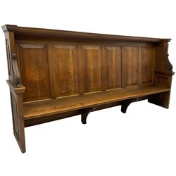 19th century oak enclosed pew, egg and dart moulded cornice over high fielded panelled wingback, fitted with foliage scroll and flower head carved brackets