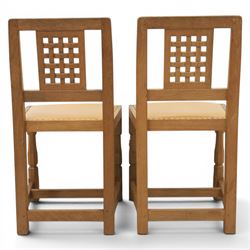 Mouseman - set of four oak lattice back chairs with tan seat with brass studded trim, with carved mouse signature, by the workshop of Robert Thompson of Kilburn