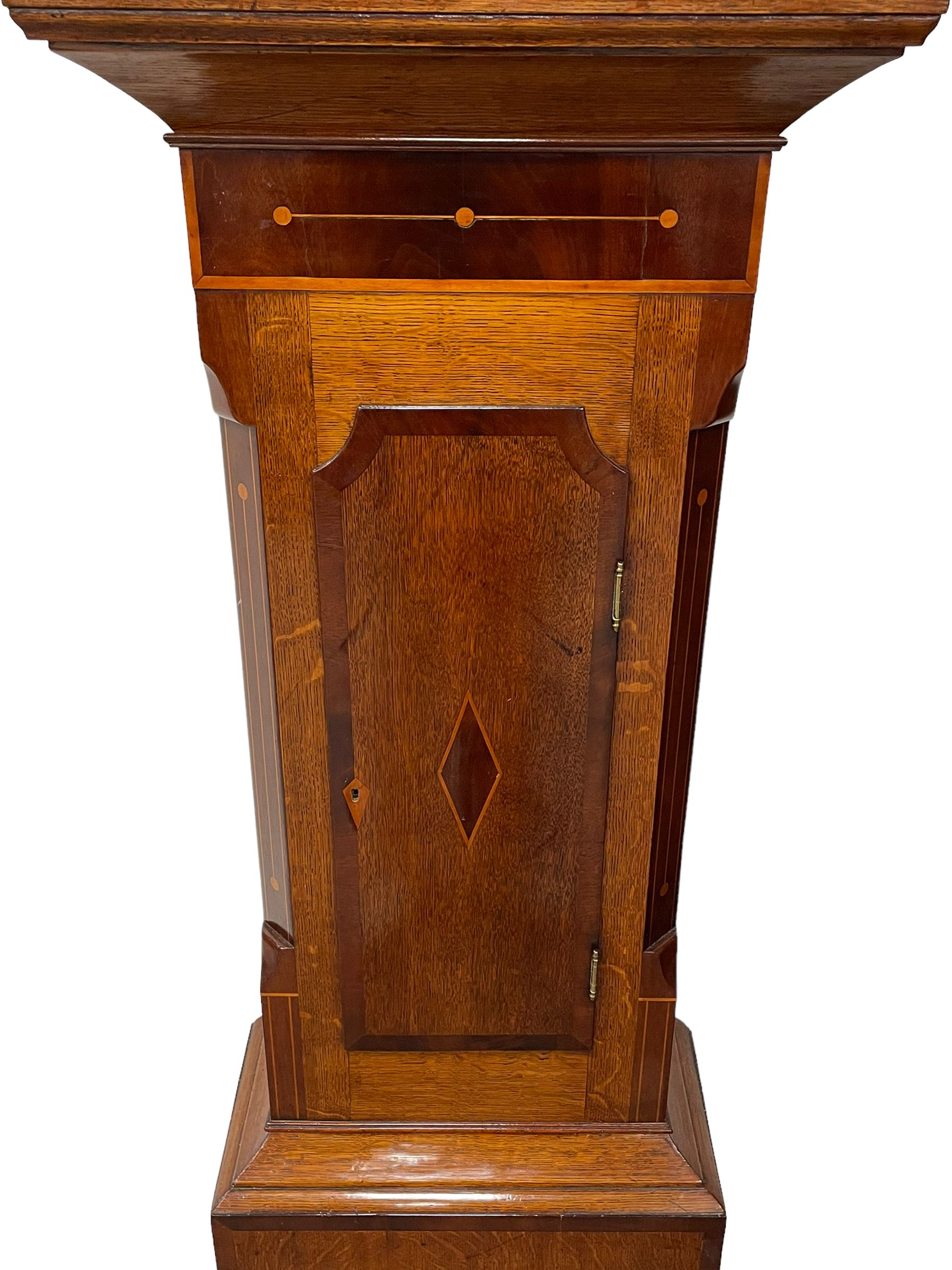 Musson of Louth - mid-19th century oak and mahogany 8-day longcase clock, with a swan’s neck pediment and ball and spire brass finial, break arch hood door flanked by reeded pilasters with brass capitals, canted angled trunk, flat topped door with concave corners, rectangular plinth on bracket feet, fully painted break arch dial with Roman numerals and minute track, subsidiary seconds dial and calendar aperture, matching stamped brass hands, eight day rack striking movement with anchor escapement. With weights and pendulum.
H206 W44 D23
Balthazar Musson from Baden (Germany) is recorded as working in Louth from 1835, naturalised 1861-8. Succeeded by his son, George Balthazar 1872-1920. 
