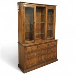 Ercol - dark elm dresser, the upper section with two glazed cupboard doors enclosing adjus...
