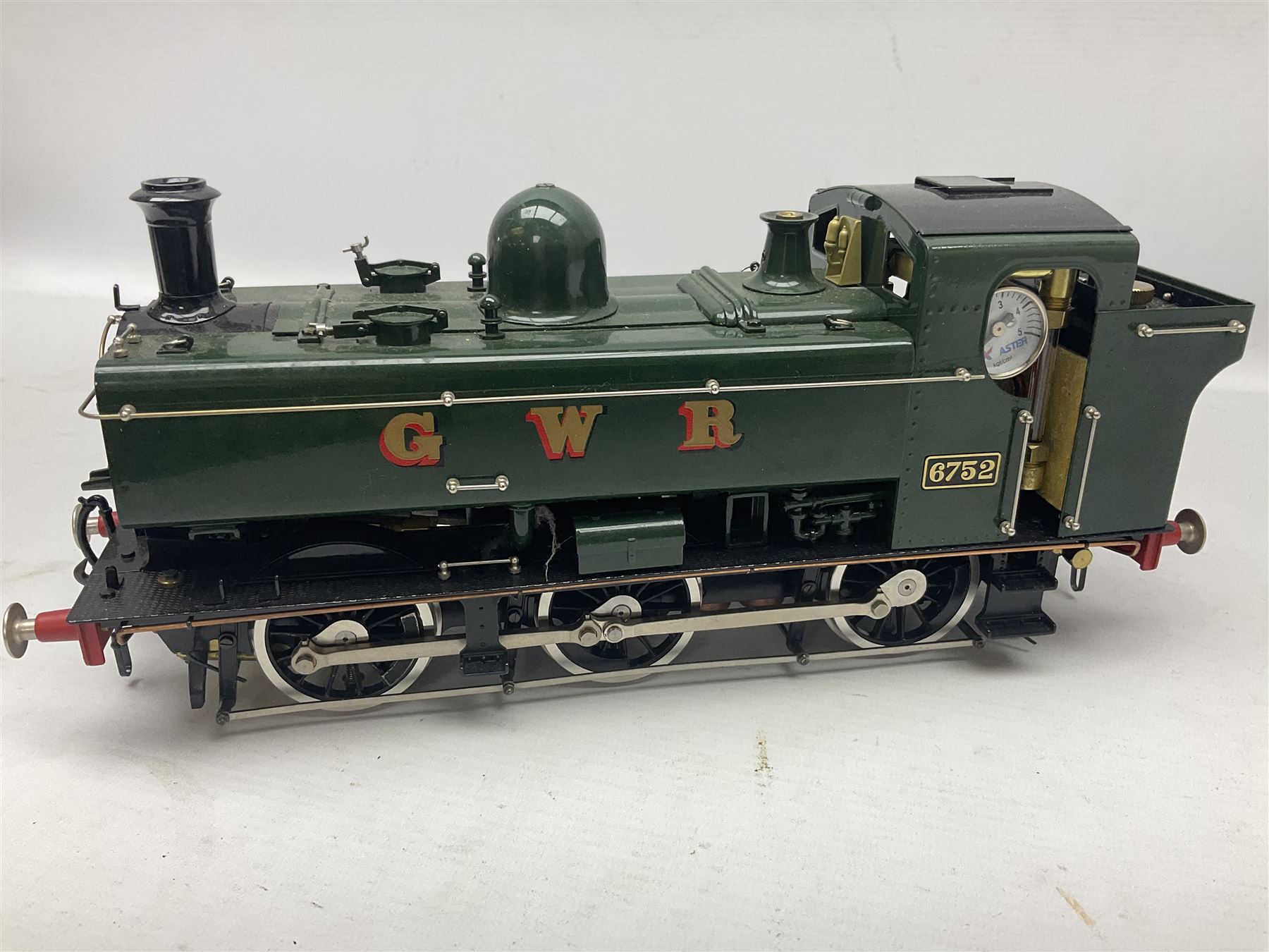 Gauge 1 - Aster 0-6-0 Great Western Railway Pannier tank locomotive No.6752; spirit fired and live steam powered with fitted steam pressure gauge, water sight glass and other usual fittings; finished in Great Western Railway green livery with GWR initials to the pannier tanks, fitted steps, handrails, checker plate, lamp irons, buffers and vacuum hoses; L31cm W8.5cm