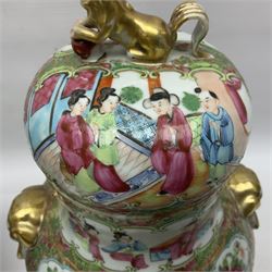 Pair of 19th century Chinese Famille Rose vases and covers, each of baluster form with twin gilt lion mask ring handles to shoulders, the flattened domed covers with gilt temple lion finials, each decorated with alternating reserves of bijin and attendants, and birds and butterflies amongst blossoming peonies, against a gilt ground profusely decorated with stylised scrolls, H32.5cm