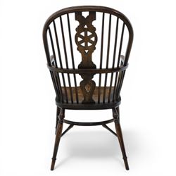Late 19th century elm and beech high back Windsor armchair, the arched hoop back centred by a pierced wheel splat above a heart shaped lower piercing, with turned spindles and shaped arm rail, saddle seat, raised on turned legs united by a crinoline stretcher