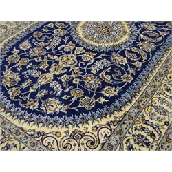  Fine Persian Nain silk and wool ivory rug, circular central medallion sat within blue ground curved rectangular field with frilled edge, scrolled foliage and stylised flower head overall design, 300cm x 195cm  