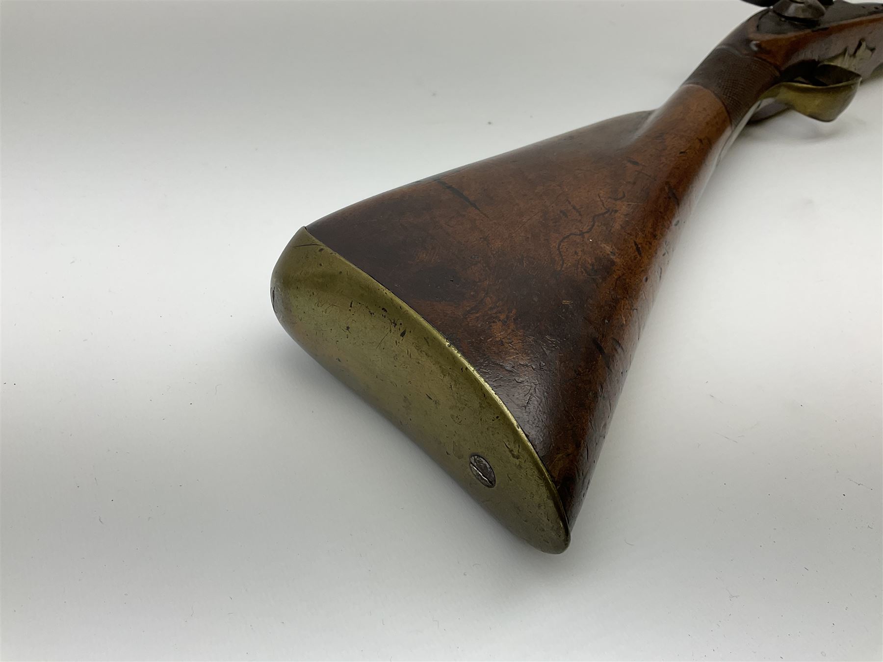 Early 19th century 15-bore flintlock converted to percussion cap fowling piece, the lock stamped T. Richards, walnut half stock with brass fittings including trigger guard with pineapple finial and 91cm barrel with ramrod under L129cm overall