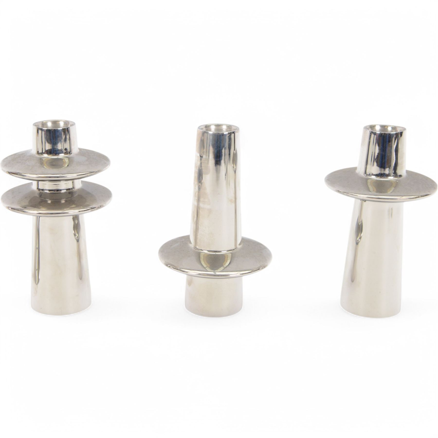 Georg Jensen set of three stainless steel candlesticks, designed by Rebecca Uth, together with another candlestick designed by Constantin Wortmann, both in original boxes   