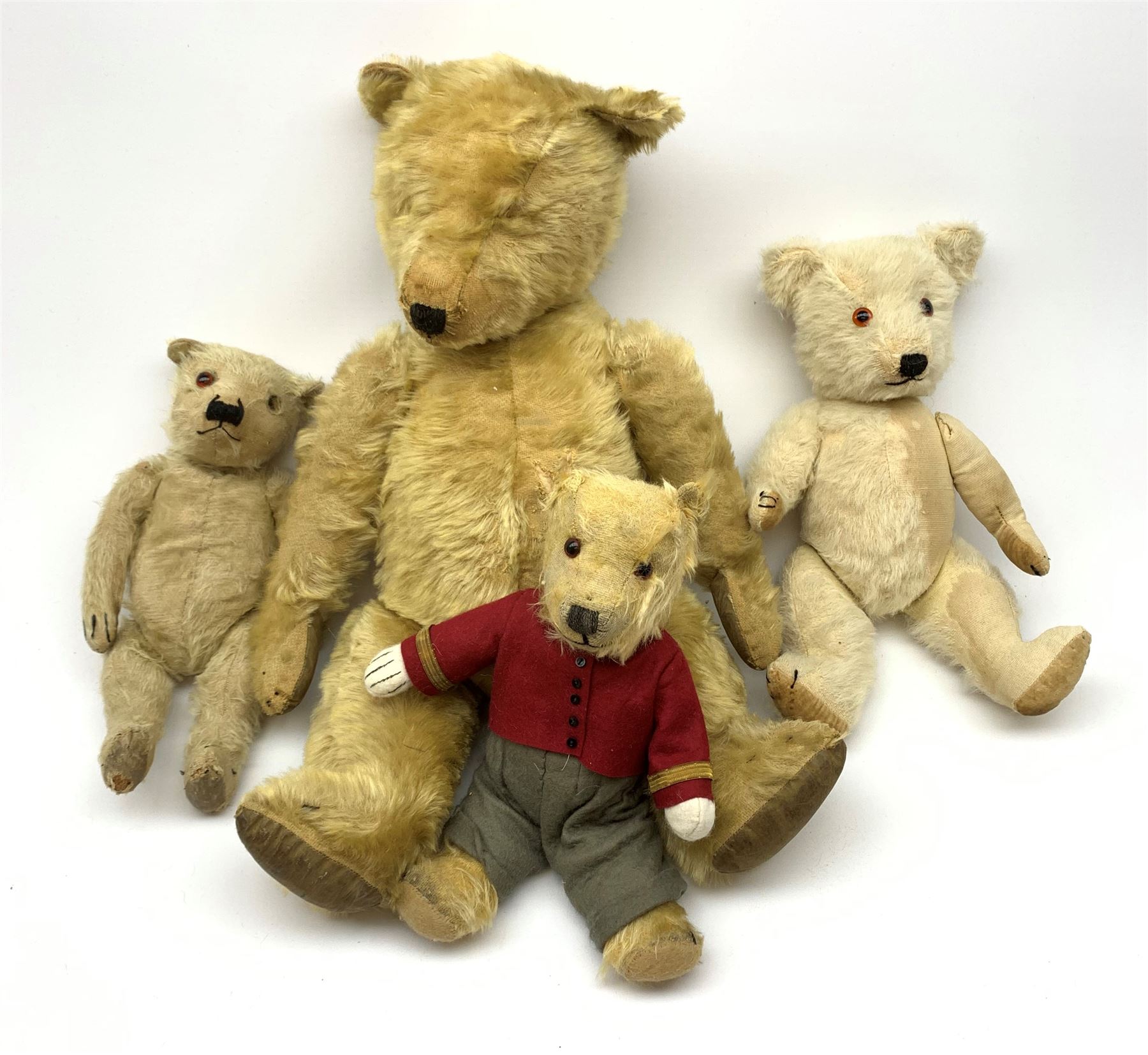 Four Chiltern teddy bears 1930s-50s, including white one with revolving head, glass type eyes, vertically stitched nose and mouth and jointed limbs with felt paw pads H16.5