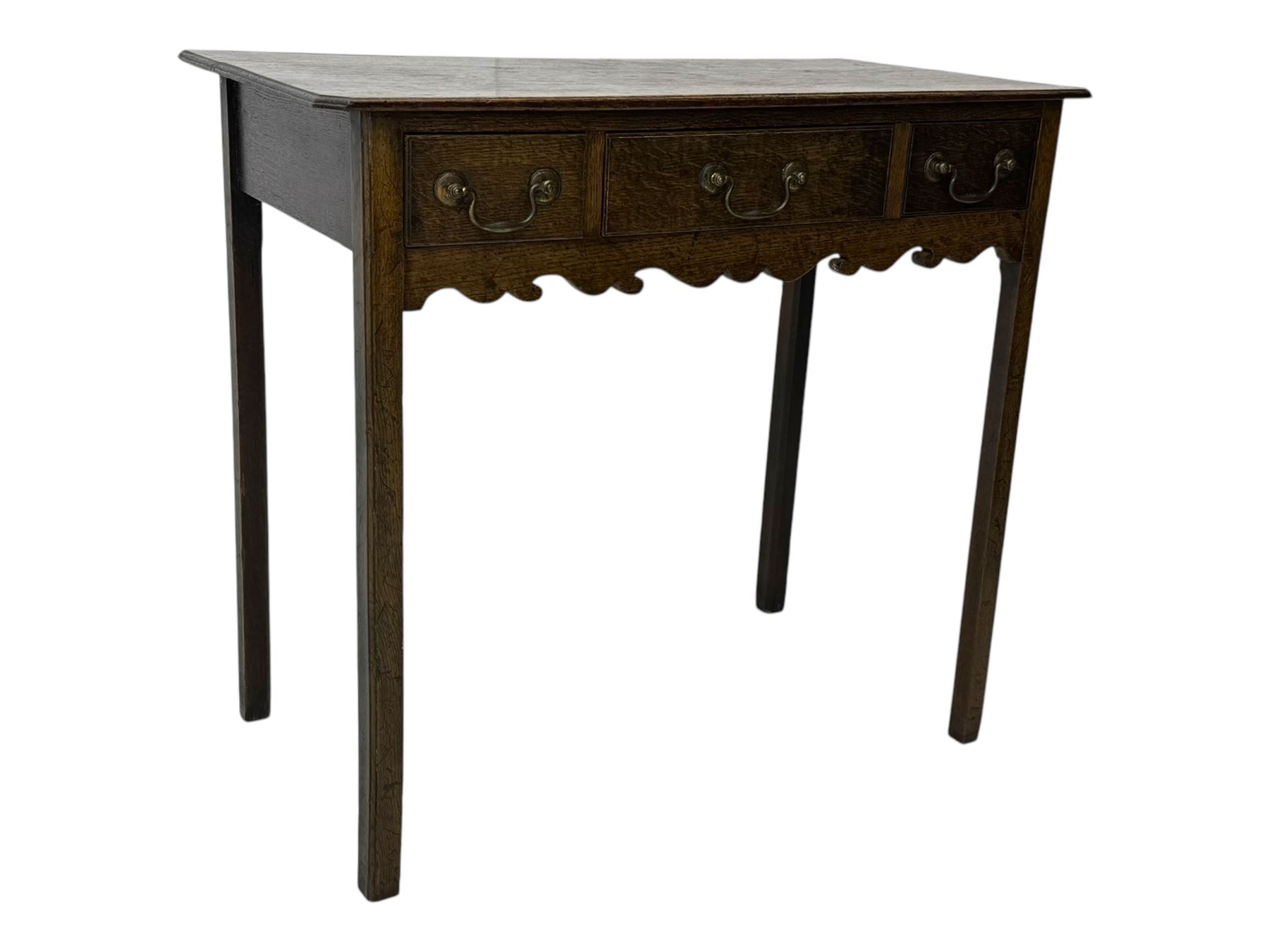 18th century oak lowboy, rectangular moulded top over three frieze drawers with brass swing handles, scalloped apron, on slender square section supports