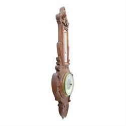 Victorian carved oak aneroid barometer, the foliate crest above a glazed thermometer, with scroll carved sides and circular dial below, H  60cm