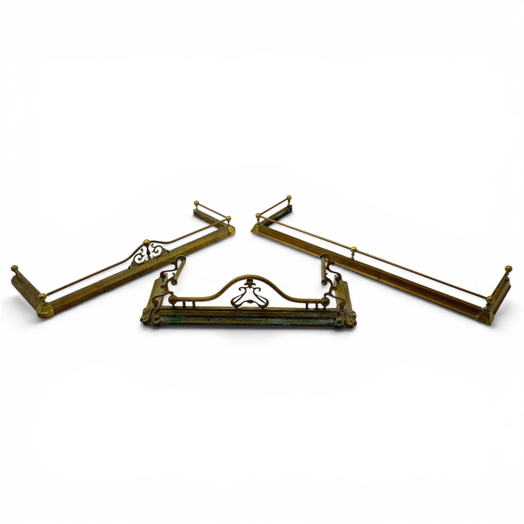 Three 20th century brass fenders, two with pierced Art & Crafts design rails, largest W156cm, D 45cm 