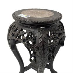 Late 19th century Chinese hardwood pedestal stand, circular top with inset marble panel, carved apron with openwork foliate and floral motifs, raised on cabriole supports with stylised claw and ball feet united by square undertier