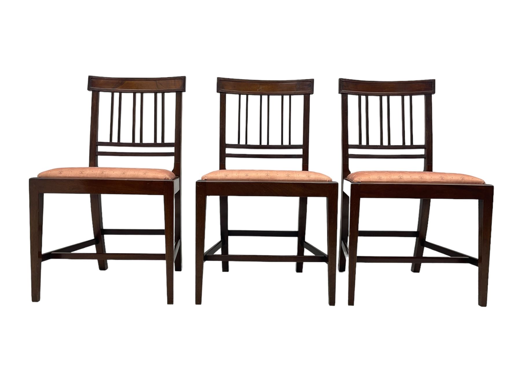 Early 20th century Regency design mahogany tilt-top table, circular top with edge banding, supported by a central turned pedestal with four reeded sabre supports terminating in castors; six chairs with pink upholstered drop in seats (7)