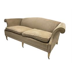 Traditional three seat sofa, curved back over scrolled arms, upholstered in crushed beige fabric with matching loose cushions, on turned front supports with brass and ceramic castors, together with matching footstool