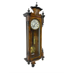 German - single train late 19th century Vienna regulator, in a walnut and ebonised case with finials and carved decoration, fully glazed case door with a visible brass weight, pendulum and beat plate, two part enamel dial with Roman numerals, pierced steel hands and subsidiary seconds dial, movement with a deadbeat escapement. 