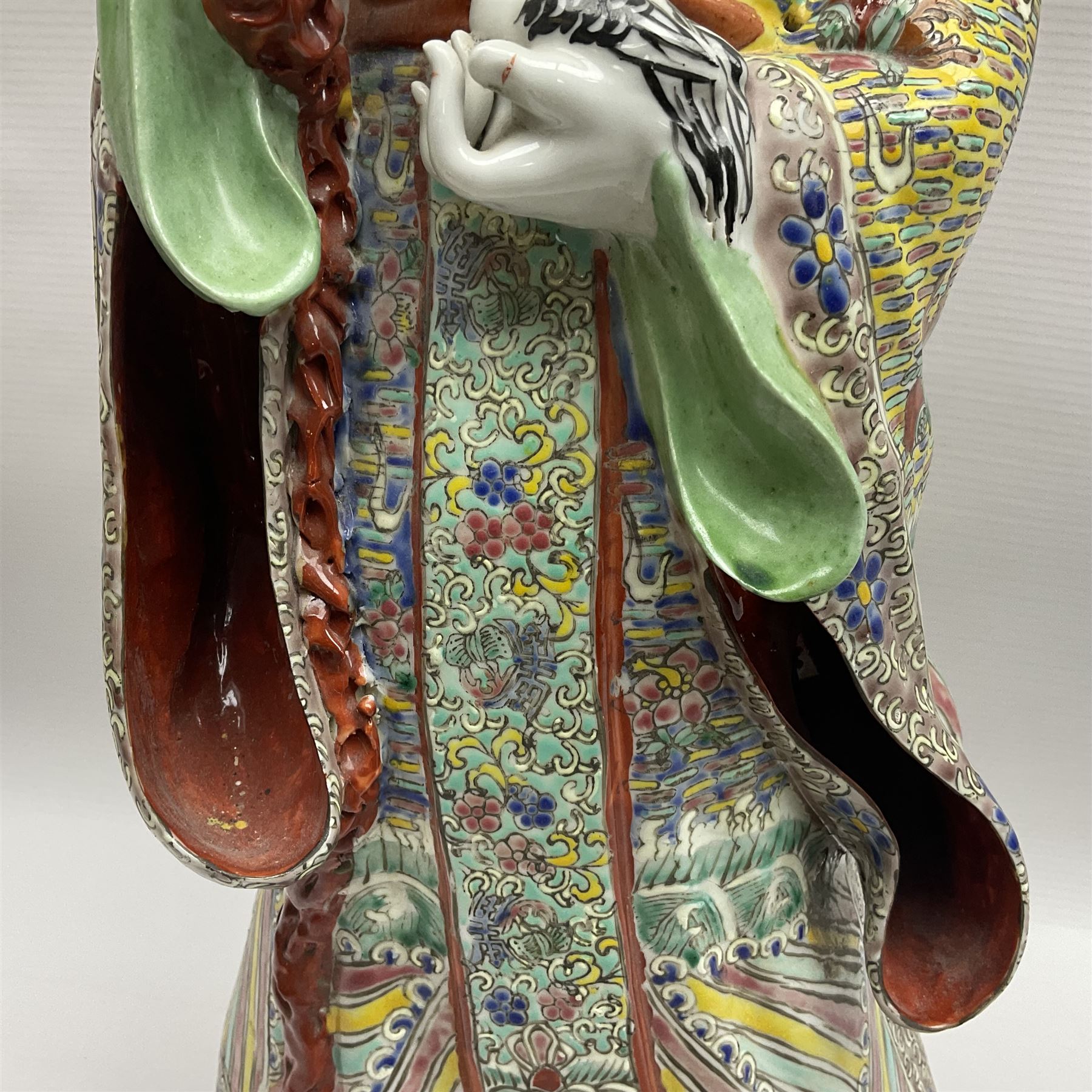 Chinese Republic Period porcelain figure, modelled as Shoulao, wearing elaborately enamelled robes decorated with peaches and flower heads, with impressed mark beneath, H55cm