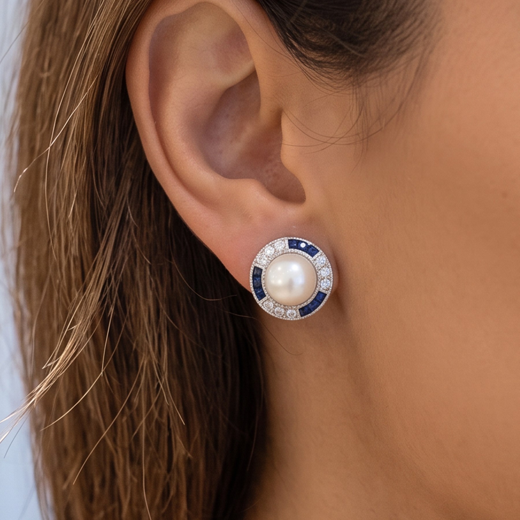 Pair of pearl, sapphire and diamond milgrain set earrings, each stud set with a cultured white pearl, surrounded by alternate calibre cut sapphires and round brilliant cut diamonds, London import mark 1994