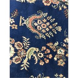 Persian Herati design indigo and red ground carpet, decorated with floral motifs, arched border
