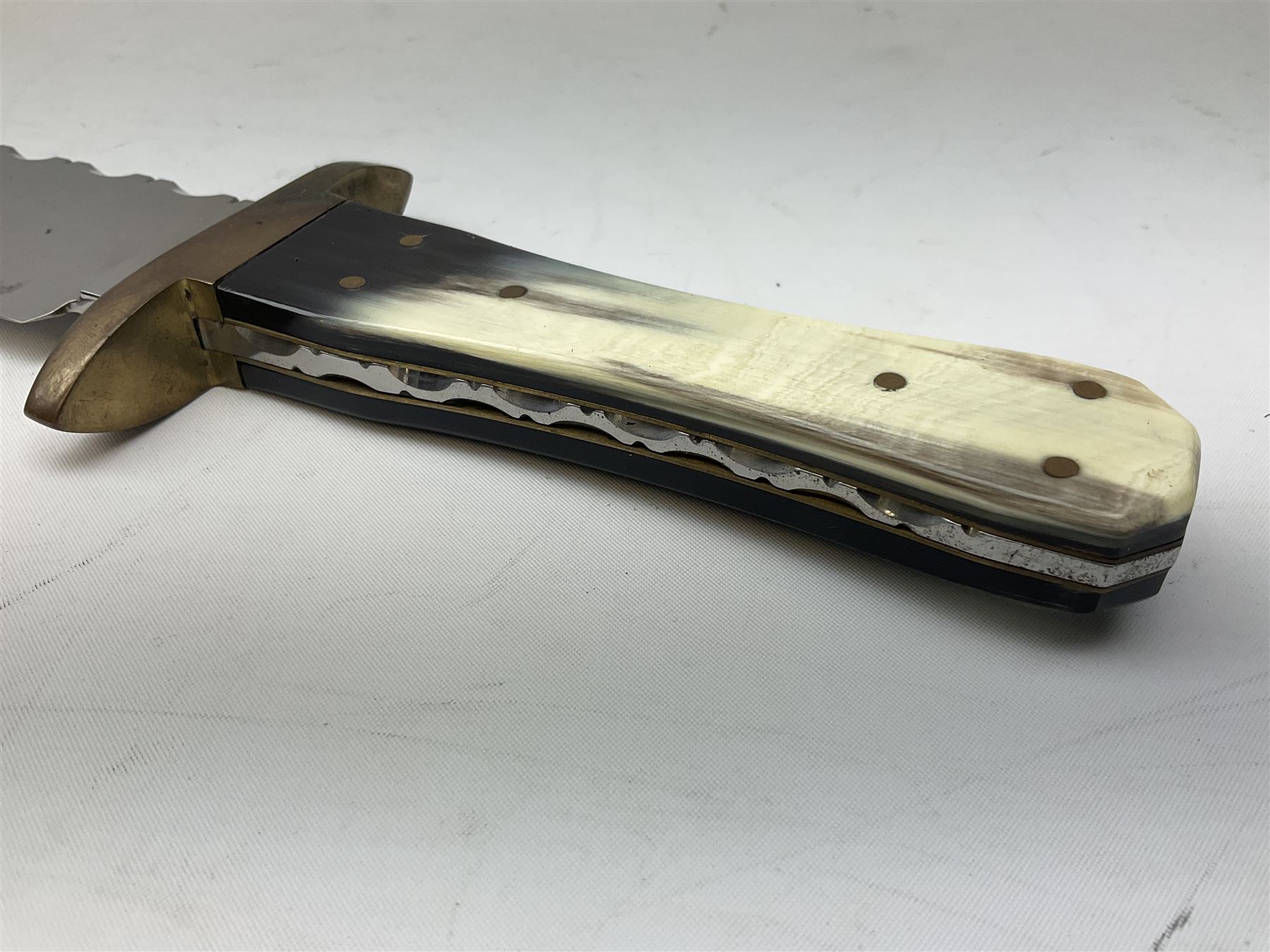 Large Bowie knife the 21cm steel blade marked J.E. Middleton & Sons Rockingham Street Sheffield with brass cross-piece and polished horn grip scales; in leather sheath L36cm overall