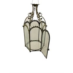 19th century brass and clear glass hexagonal hall lantern, with scrolling wire work open domed top over six arched panels, including a hinged door, the base enclosed with a circular glass panel on turned feet, H64cm
