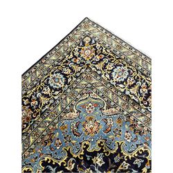 Persian Kashan indigo ground carpet, floral pattern light blue ground central medallion and spandrels, the fielding decorated with interlacing leafy branches and palmettes, the repeating floral pattern border enclosed within guard stripes