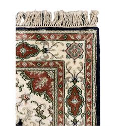 Turkish Cappadocia silk inlaid ivory ground rug, the central medallion in indigo field decorated with trailing foliate and scrolling, the border with repeating panels and foliate motifs 
