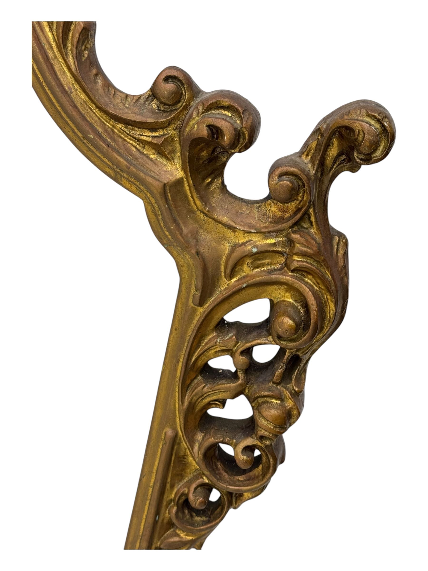 Victorian design gilt framed overmantel mirror, the arched and moulded frame adorned with scrolling foliate motifs and acanthus leaves, surmounted by a pierced cartouche, plain mirror plate, resting on a shaped base