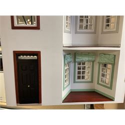 'The Hollies' - good quality sectional wooden doll's house in the form of a Georgian style four-storey bay windowed town house with simulated brick front elevation, rendered sides, off-set corner stonework, faux slate-hung top floor with flat roof and chimney stack, working sash windows, iron railings around front basement courtyard with hinged front elevation to two rooms with  spiral staircase, side hinged central section approached by external steps with iron balustrades to the sides leading to a front door, entrance hall with stairs to landing and two rooms on two floors with dado panelling and fire-surrounds, the top floor with top hung front elevation revealing stairs to a landing and bedroom; wired for electricity L51cm D65cm H107cm including chimney; together with a good quantity of quality wooden furniture and accessories including piano, dressers, bookcase and books, rugs, double half-tester bed, metalware, pictures etc