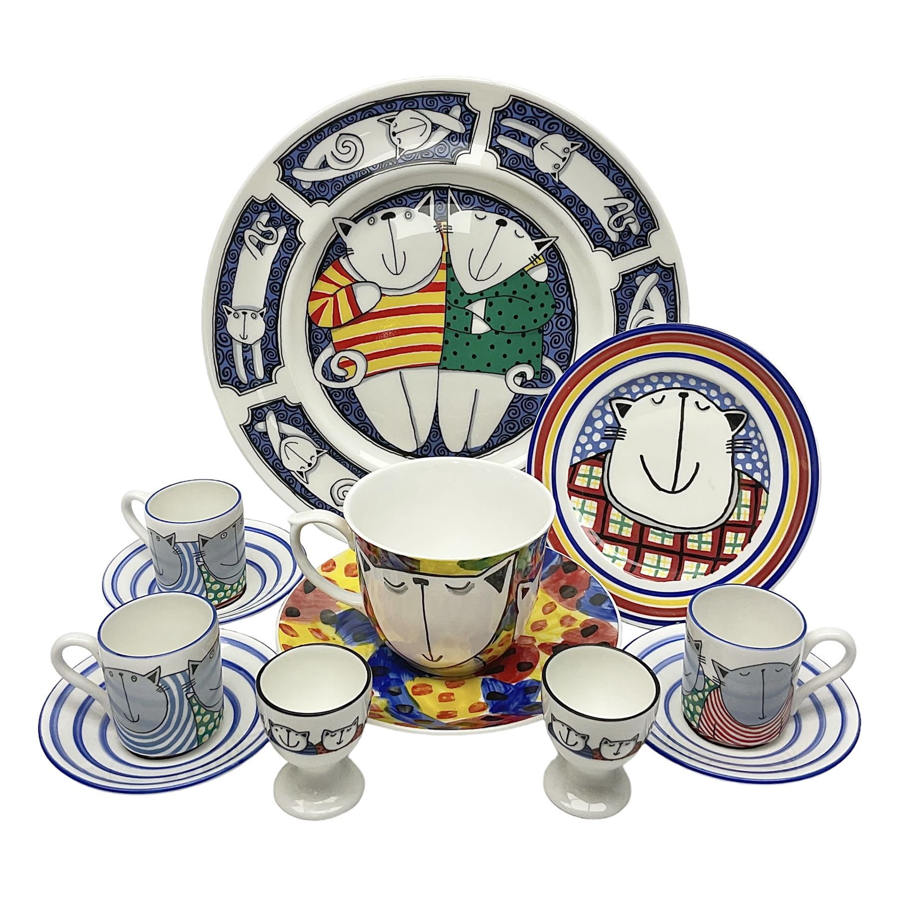 Modern studio pottery by Josie Firmin, to include cup and saucer, three espresso cups and saucers, pair of egg cups etc, each hand painted with varying cartoon cat designs