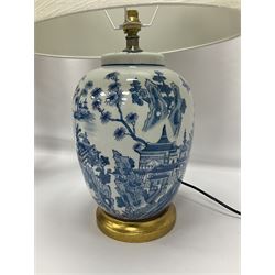 Pair of Chinese porcelain blue and white lamps in the form of ginger jars and covers, each decorated with landscape scene, raised upon gilt circular base, including shade H63cm