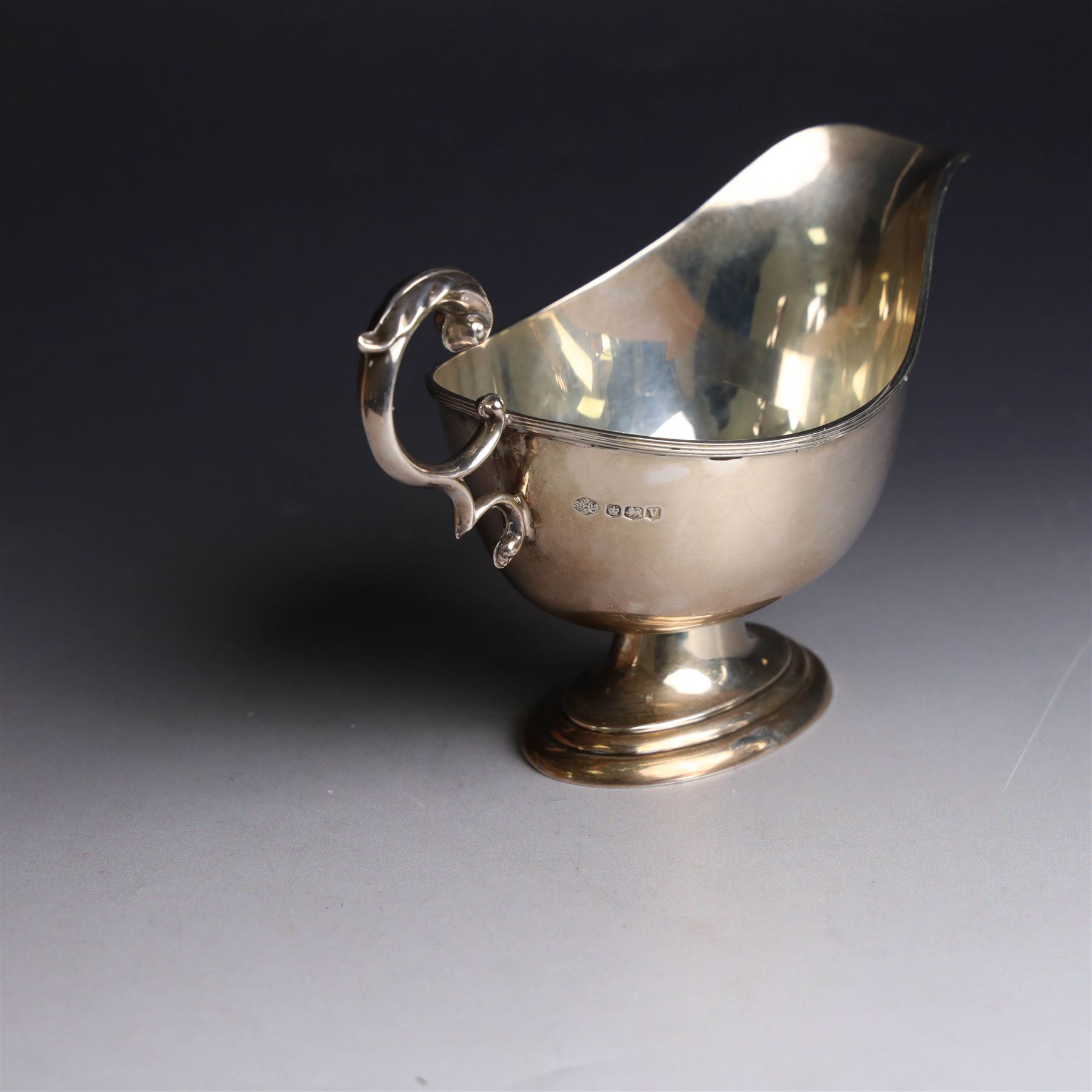 1930s silver sauce boat, of typical form with acanthus capped flying C scroll handle and upon stepped oval foot, hallmarked William Hutton & Sons Ltd, Sheffield 1938, height including handle H10cm