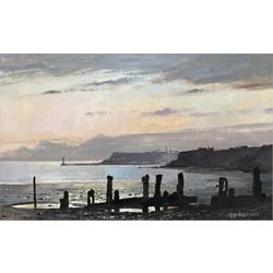 Don Micklethwaite (British 1936-): Whitby from Sandsend at Twilight, oil on canvas laid on...