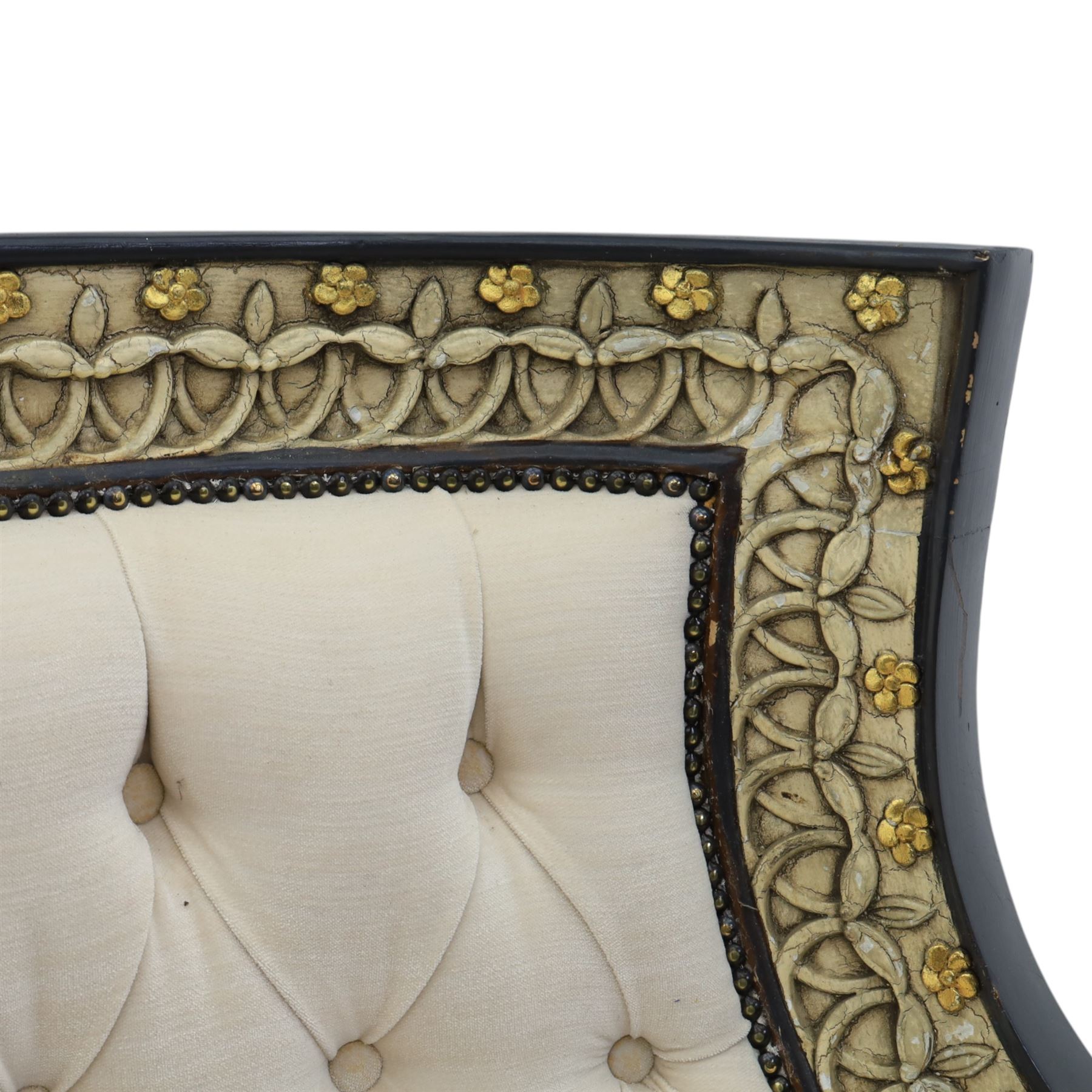 20th century Louis XVI style settee, upholstered in cream fabric with buttoned back and arms, and plain seat cushions, the shaped and black painted frame with entwined foliate detail and gilt flower heads, upon column legs with bun feet