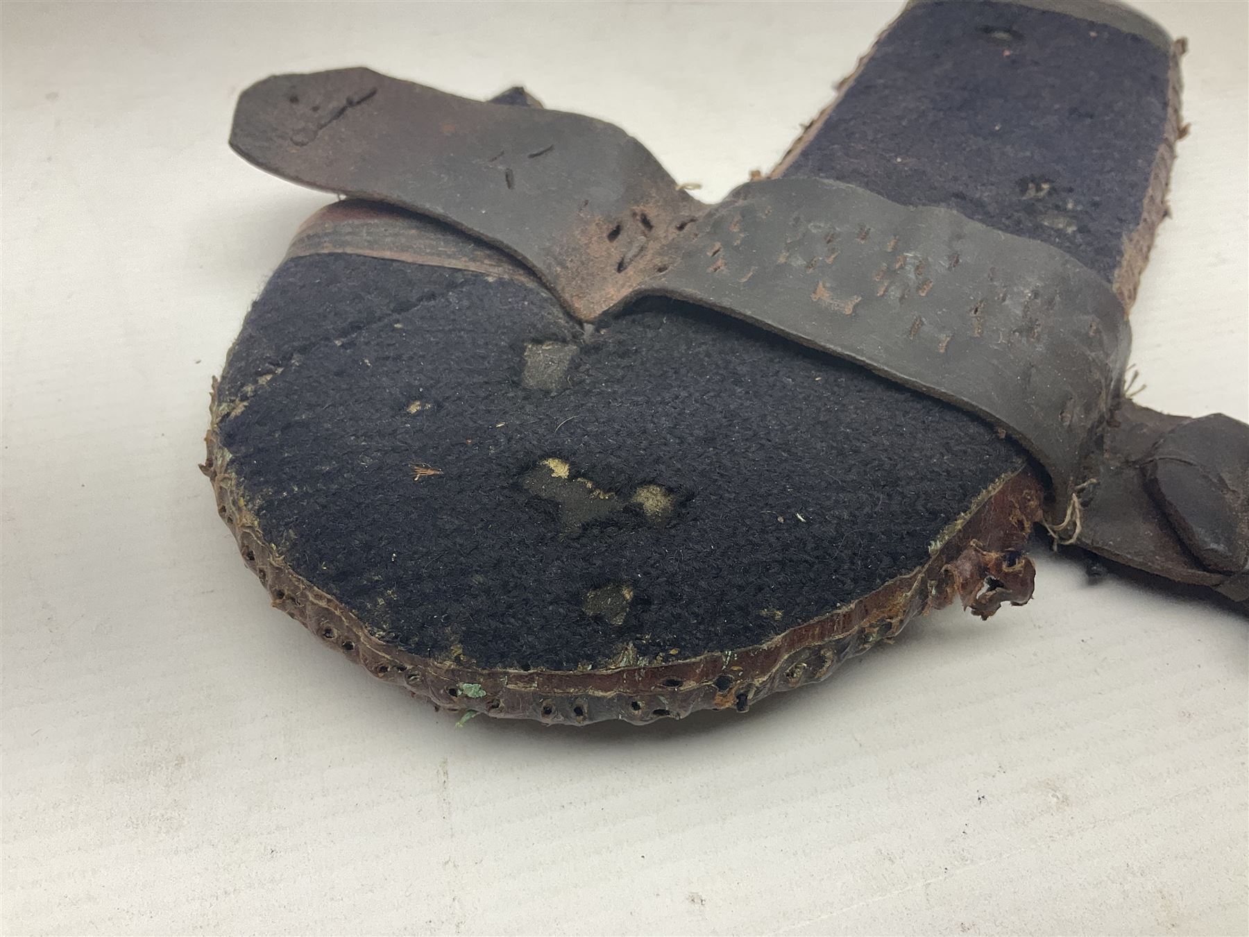 Eastern Jambiya, the 19cm double edge steel blade with raised medial ridge, waisted horn grip with pique work and white metal band; in stitched leather scabbard L33cm overall
